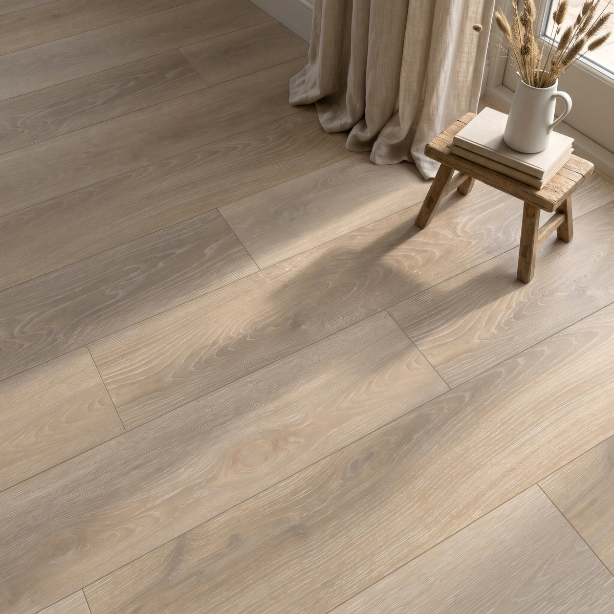 Alderley Light Wood Effect tiles laid as a floor in a room with a linen curtain and a small wooden stool holding a jug of