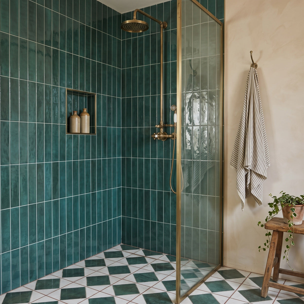 Opal Emerald wall tiles lining a walk-in shower with brass-framed glass screen, green-and-white diamond floor tiles below